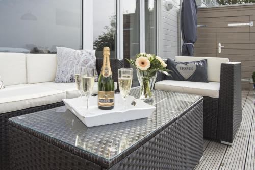 uma mesa com uma garrafa de champanhe e copos em Bootshaus em Olpenitz