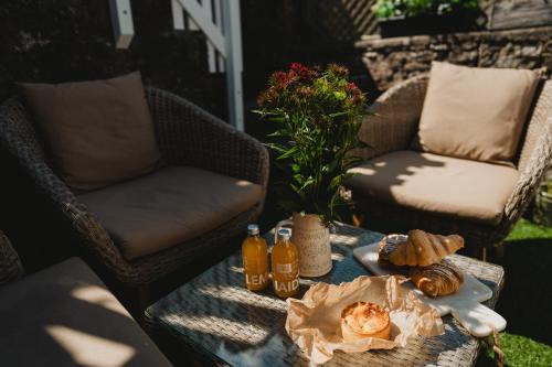 einen Tisch mit Speisen und Getränken auf einer Terrasse in der Unterkunft Swallow Cottage, Bakewell in Bakewell