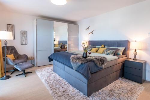 een slaapkamer met een groot blauw bed en een stoel bij cloud nine in Olpenitz