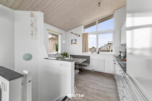 a kitchen with white cabinets and a sink and a window at Ferienhaus Marina Lounge Wendtorf in Wendtorf