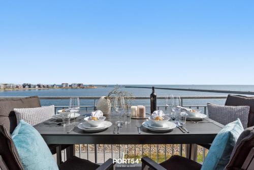 een tafel op een balkon met uitzicht op de oceaan bij Seewind in Olpenitz