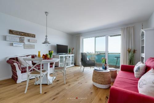 a living room with a red couch and a table at Seestern in Olpenitz