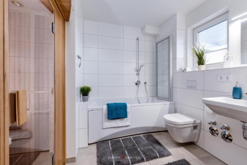 une salle de bain avec une baignoire, des toilettes et un lavabo dans l'établissement Ostseeskipper, à Olpenitz