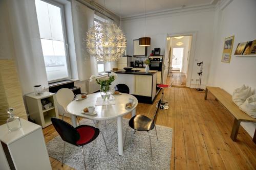uma sala de estar com uma mesa branca e cadeiras em Albatros em Flensburg