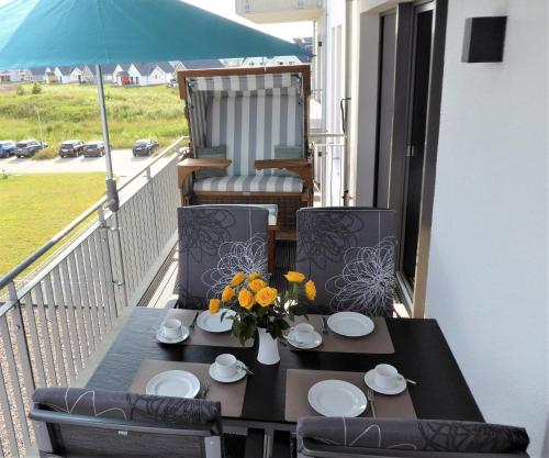 a black table with a vase of flowers on a balcony at Apartment Sterntaucher in Olpenitz