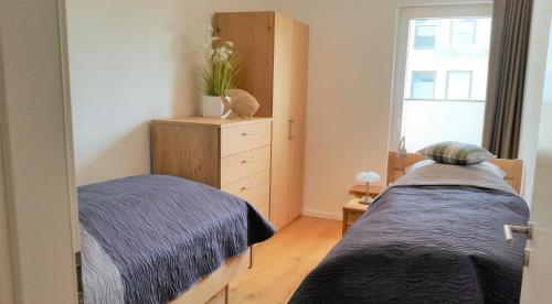 a bedroom with two beds and a dresser at Apartment Sterntaucher in Olpenitz