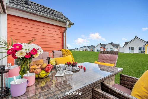 a patio with a table with fruit and flowers on it at Captainslodge in Olpenitz