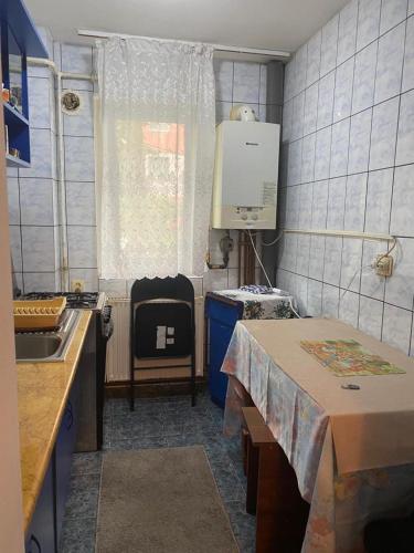 a small kitchen with a table and a sink at Apartament parter in Craiova