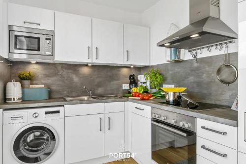 a white kitchen with a sink and a dishwasher at Captainslodge in Olpenitz