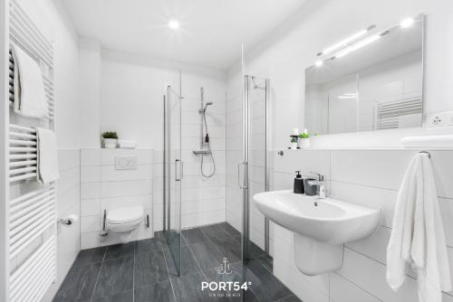 uma casa de banho branca com um lavatório e um chuveiro em Meerzeit Damp em Damp