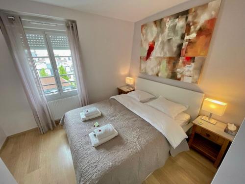 1 dormitorio con 1 cama con 2 toallas en Family's Appartement Disney Paris , 2 Parking, en Serris