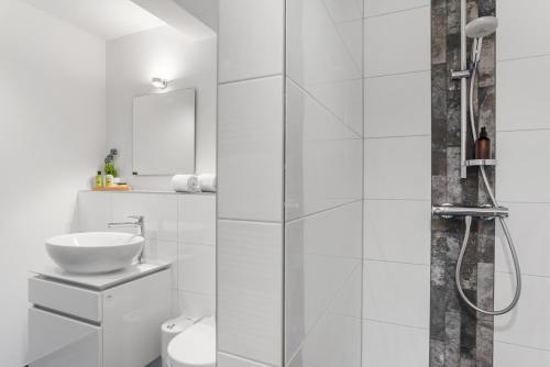 a white bathroom with a shower and a sink at Flaute in Sankt Peter-Ording