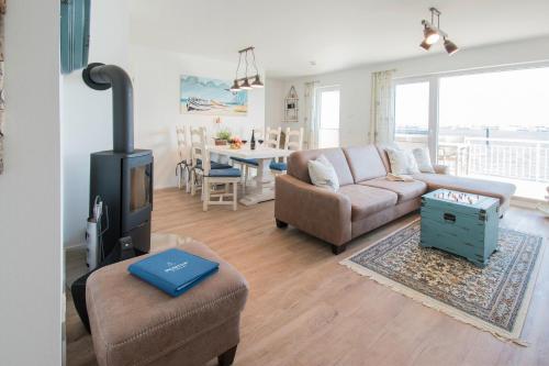 ein Wohnzimmer mit einem Sofa und einem Herd in der Unterkunft Meeresmelodie in Olpenitz