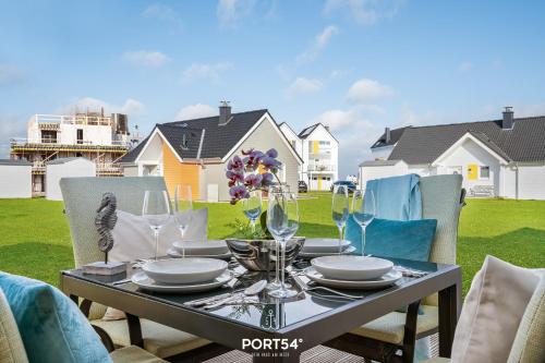 un tavolo con piatti e bicchieri da vino su un patio di Weisse Düne II a Olpenitz