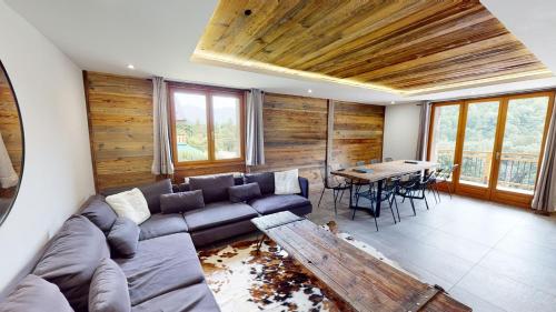 ein Wohnzimmer mit einem Sofa und einem Tisch in der Unterkunft Chalet Jogidi in Saint-Sorlin-dʼArves