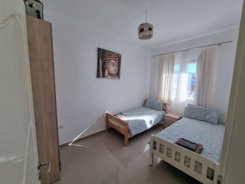 - un salon avec deux lits et une fenêtre dans l'établissement Modern & Spacious 3 bedroom First Floor Apartment/Villa, à Tirana