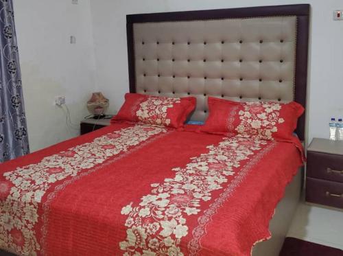 - une chambre avec un lit rouge et une couette rouge dans l'établissement Savagem Furnished Apartment, à Freetown