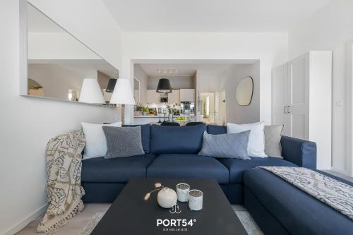 un salon avec un canapé bleu et une table dans l'établissement Ferienwohnung Freiherr, App 8 Emmelsbüll, à Emmelsbüll-Horsbüll