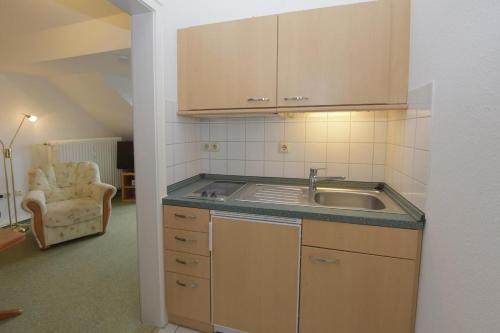 uma cozinha com um lavatório e uma cadeira num quarto em Nordsee em Büsum