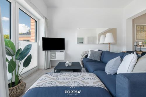 un salon avec un canapé bleu et une télévision dans l'établissement Ferienwohnung Freiherr, App 8 Emmelsbüll, à Emmelsbüll-Horsbüll