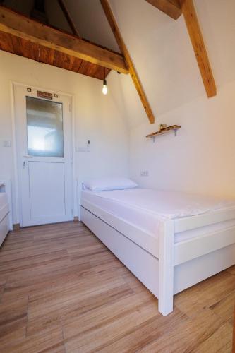 a bedroom with a large white bed in a room at Resort La Familia in Bihać