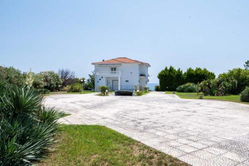 a large white house with a large driveway at Villa Mae in Elaiokhórion