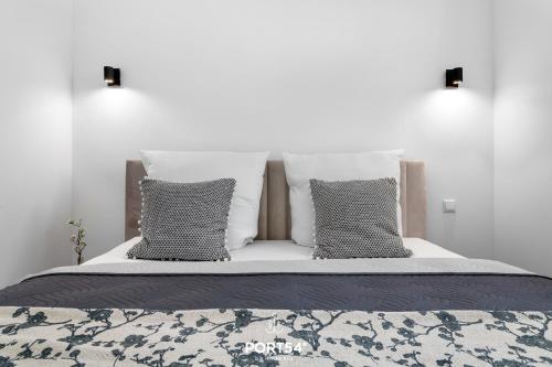 a bed with four pillows and a white wall at Strandläufer Gelting in Gelting