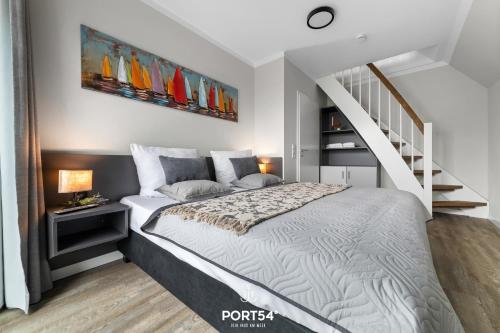 1 dormitorio con 1 cama grande y una escalera en Momme II en Büsum