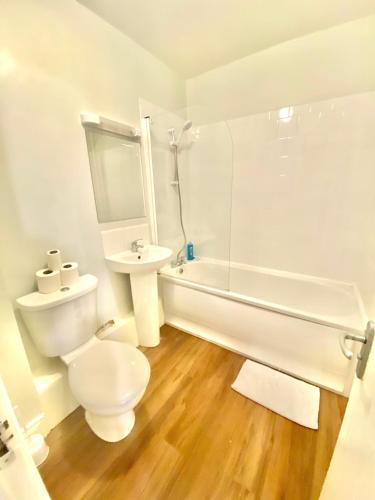 La salle de bains blanche est pourvue de toilettes et d'un lavabo. dans l'établissement Lovely 2 bedroom apartment in Dublin City, à Dublin