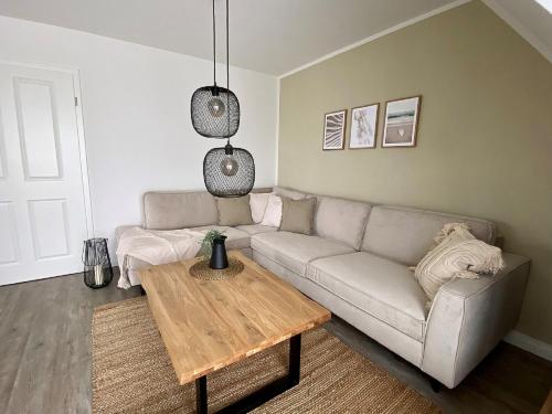 ein Wohnzimmer mit Sofa und Tisch in der Unterkunft Salzwiesenblick in Büsum