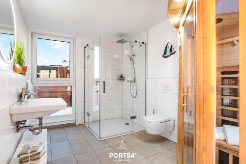 ein Bad mit einer Dusche, einem WC und einem Waschbecken in der Unterkunft Strand Loft in Olpenitz
