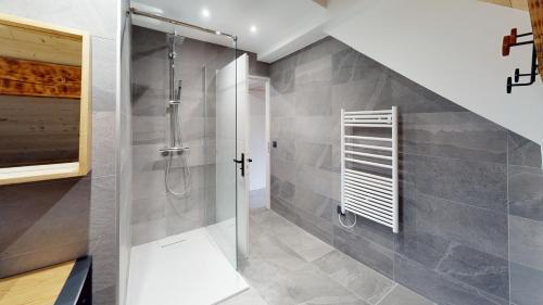 a bathroom with a shower with a glass door at Chalet Jogidi in Saint-Sorlin-dʼArves