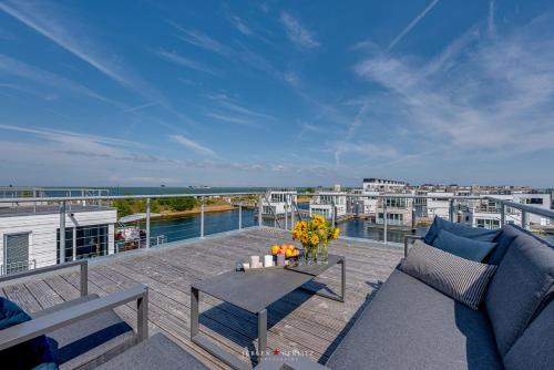 eine Terrasse mit einem Sofa und einem Tisch auf dem Balkon in der Unterkunft Surfer's Bay in Olpenitz