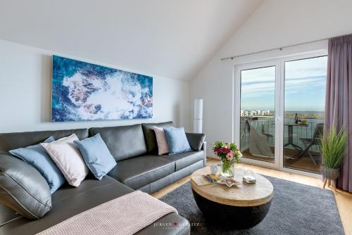 ein Wohnzimmer mit einem Sofa und einem Tisch in der Unterkunft Sailors View in Olpenitz