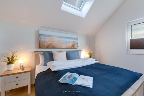 a bedroom with a large bed with a book on it at Sailors View in Olpenitz
