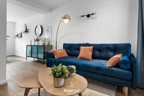 a living room with a blue couch and a table at Leneshus in Flensburg