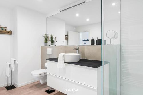 une salle de bain blanche avec un lavabo et des toilettes dans l'établissement Ferienwohnung Grüne Freiheit, App 14 Emmelsbüll, à Emmelsbüll-Horsbüll