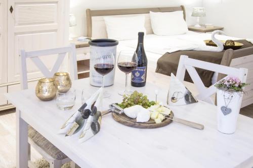 einen Tisch mit einer Flasche Wein und einem Teller Essen in der Unterkunft Biberburg in Flensburg