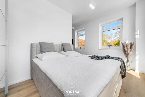 a bedroom with a large bed with white walls at Strandgut Gelting in Gelting