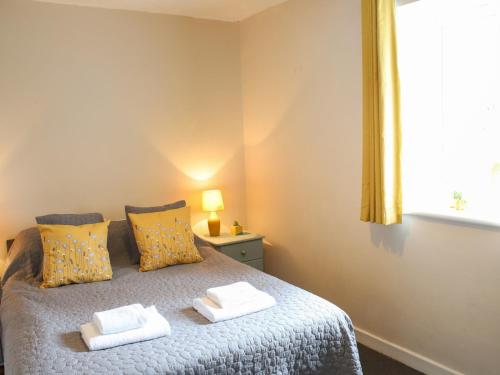 sypialnia z łóżkiem z dwoma ręcznikami w obiekcie Pass the Keys Pet friendly Garden flat in Carmarthen w mieście Carmarthen