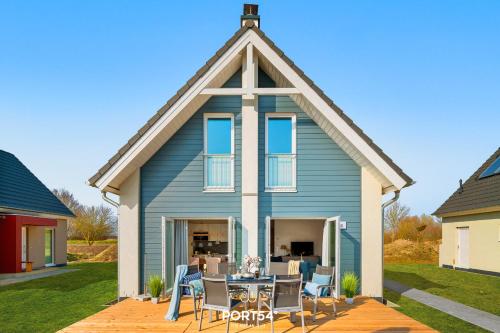 a blue house with a table and chairs at Ferienhaus Nordseeresort 55 Meerglück Büsum in Büsum