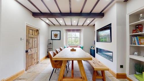 a dining room with a wooden table and chairs at Nidd House Farm in Harrogate