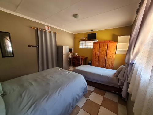 a hotel room with two beds and a kitchen at N4 Guest Lodge in Rustenburg