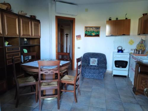 Il comprend une cuisine équipée d'une table, de chaises et d'une cuisinière. dans l'établissement Appartamento "Il Glicine", à Torraca
