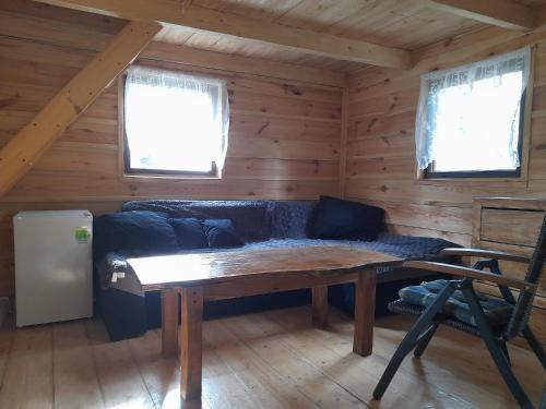 a living room with a blue couch in a log cabin at Glamping pod hradem in Česká Kamenice