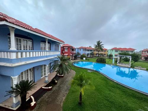 an aerial view of a resort with a swimming pool at Nestwood - By The Beach Goa in Benaulim