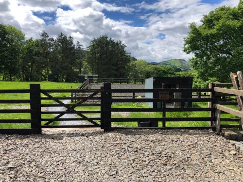 a wooden fence in front of a field at Shepherds Hut at The Retreat in Oswestry