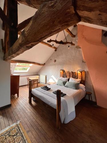 ein Schlafzimmer mit einem großen Bett im Dachgeschoss in der Unterkunft Gite de l'Oeil in Saint-Pierre-de-Fursac