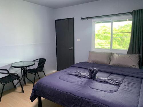 1 dormitorio con 1 cama con mesa y sillas en บ้านวนัชชา รีสอร์ท en Wang Nam Khieo