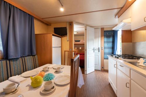 a kitchen with a table with plates and fruit on it at Camping Village Garden Paradiso in Cavallino-Treporti